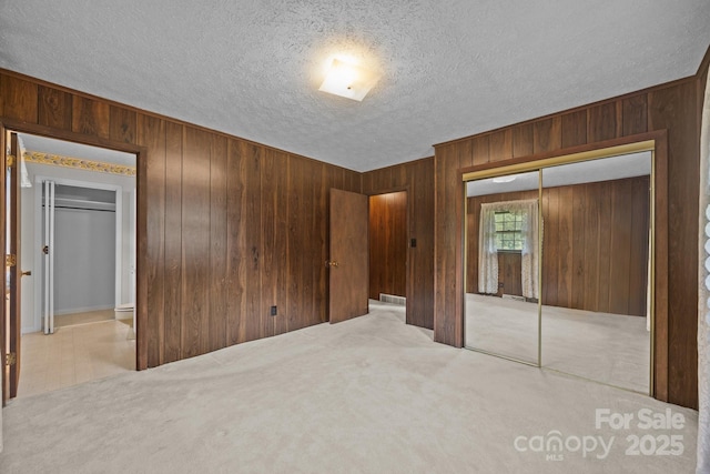 18 Progress Ln, Candler, NC 28715 - unfurnished bedroom with wood walls, a closet, a textured ceiling, and carpet