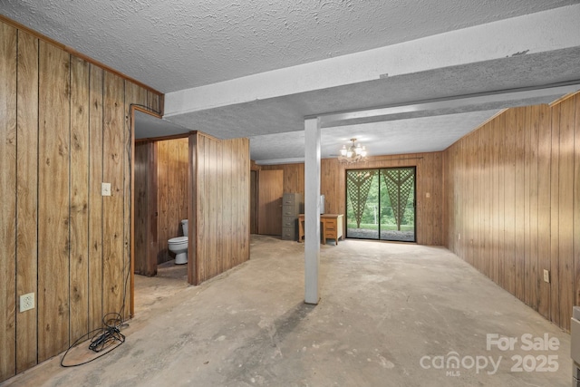 18 Progress Ln, Candler, NC 28715 - unfurnished living room featuring wood walls and unfinished concrete flooring