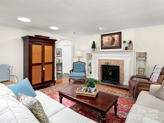 64 Wells Ln, Tryon, NC 28782 - living room featuring wood finished floors, a tiled fireplace, and ornamental molding