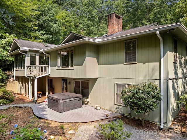 64 Wells Ln, Tryon, NC 28782 - back of property with a chimney, a hot tub, a deck, and roof with shingles
