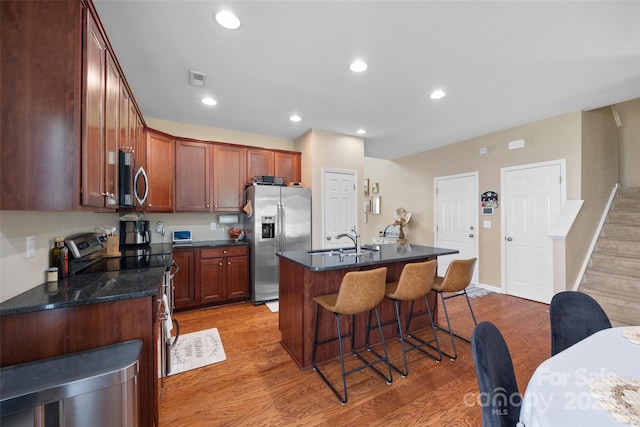 673 Stonehenge Dr, Rock Hill, SC 29730 - kitchen featuring appliances with stainless steel finishes, light wood-style flooring, a breakfast bar area, a kitchen island with sink, and recessed lighting