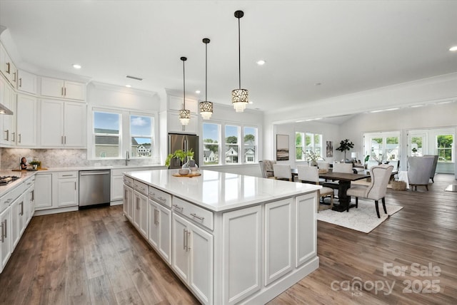 1106 Pomar Cir, Waxhaw, NC 28173 - kitchen featuring appliances with stainless steel finishes, decorative backsplash, white cabinetry, light countertops, and a kitchen island