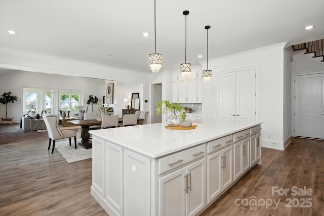 1106 Pomar Cir, Waxhaw, NC 28173 - kitchen featuring white cabinets, a center island, recessed lighting, wood finished floors, and light countertops