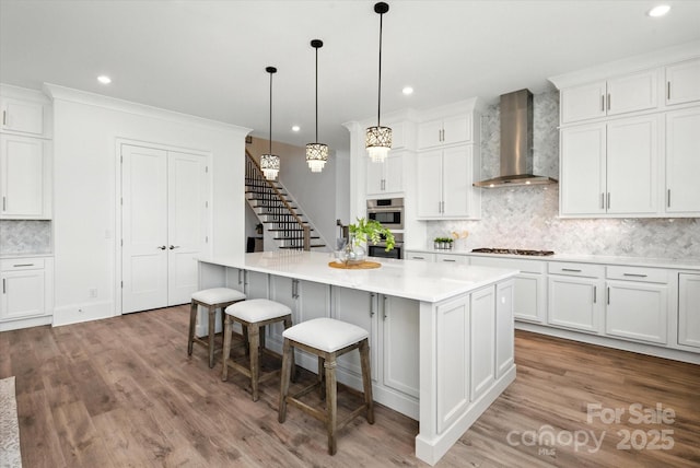 1106 Pomar Cir, Waxhaw, NC 28173 - kitchen with wall chimney exhaust hood, decorative backsplash, wood finished floors, white cabinetry, and a kitchen island
