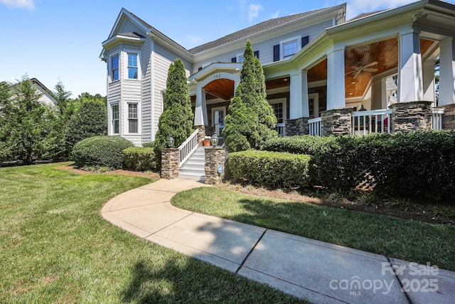 123 Yellow Jacket Cir, Mooresville, NC 28117 - view of front of house featuring a front lawn, ceiling fan, covered porch, and stone siding