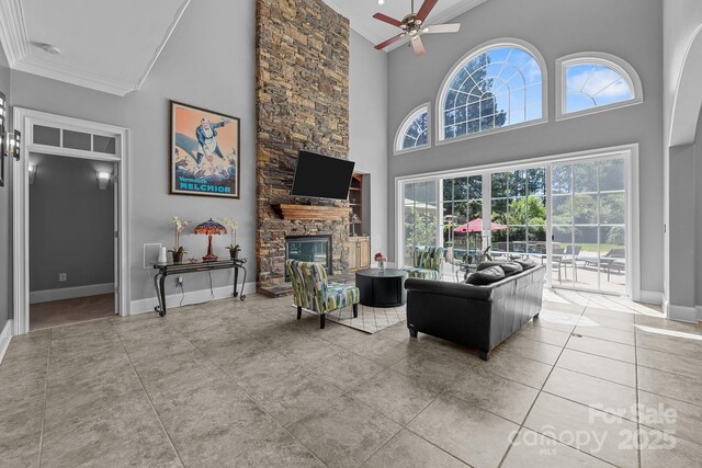 123 Yellow Jacket Cir, Mooresville, NC 28117 - living area with ornamental molding, a high ceiling, a stone fireplace, ceiling fan, and tile patterned floors