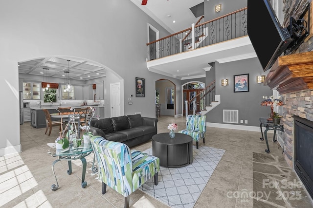 123 Yellow Jacket Cir, Mooresville, NC 28117 - living room with arched walkways, crown molding, stairs, a fireplace, and a towering ceiling