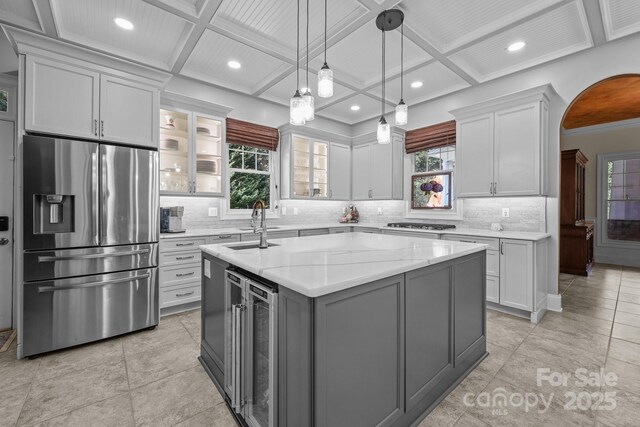 123 Yellow Jacket Cir, Mooresville, NC 28117 - kitchen featuring stainless steel appliances, wine cooler, a center island with sink, coffered ceiling, and decorative backsplash