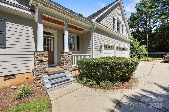 123 Yellow Jacket Cir, Mooresville, NC 28117 - doorway to property featuring a porch, a garage, and concrete driveway
