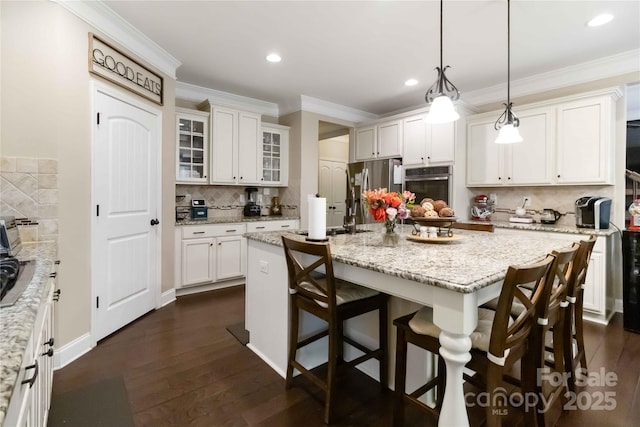 1041 Verbena Ct, Tega Cay, SC 29708 - kitchen featuring stainless steel appliances, a kitchen breakfast bar, white cabinetry, decorative backsplash, and recessed lighting