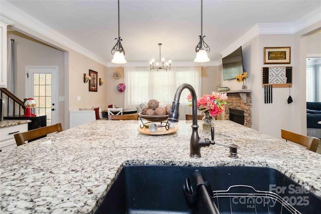 1041 Verbena Ct, Tega Cay, SC 29708 - kitchen featuring crown molding, a chandelier, light stone counters, and decorative light fixtures