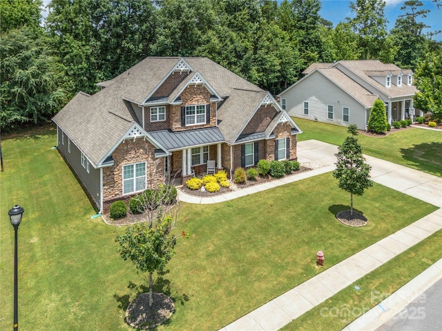 1041 Verbena Ct, Tega Cay, SC 29708 - craftsman house with stone siding, a standing seam roof, covered porch, a front lawn, and roof with shingles