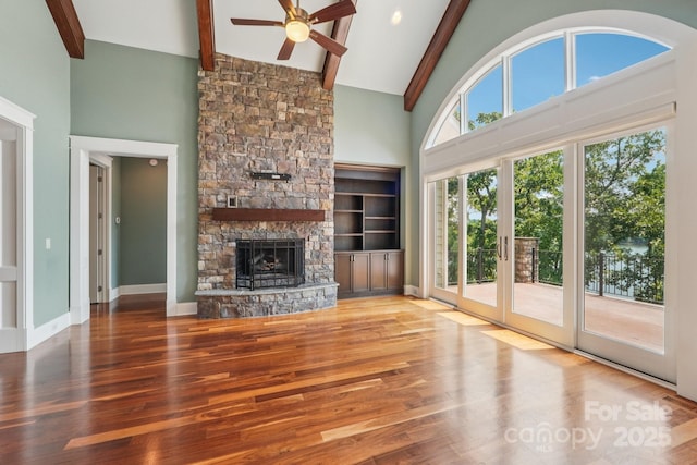 3229 Lake Pointe Dr, Belmont, NC 28012 - unfurnished living room with high vaulted ceiling, wood finished floors, a ceiling fan, beam ceiling, and a stone fireplace