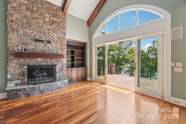 3229 Lake Pointe Dr, Belmont, NC 28012 - unfurnished living room featuring wood finished floors, a stone fireplace, beamed ceiling, and high vaulted ceiling