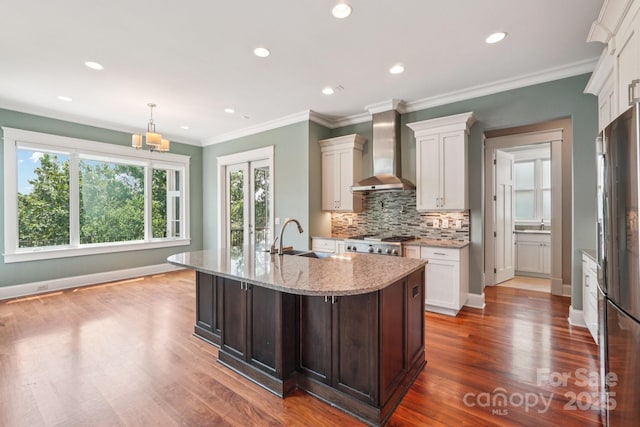 3229 Lake Pointe Dr, Belmont, NC 28012 - kitchen with wall chimney range hood, stainless steel refrigerator with ice dispenser, tasteful backsplash, light stone countertops, and wood finished floors