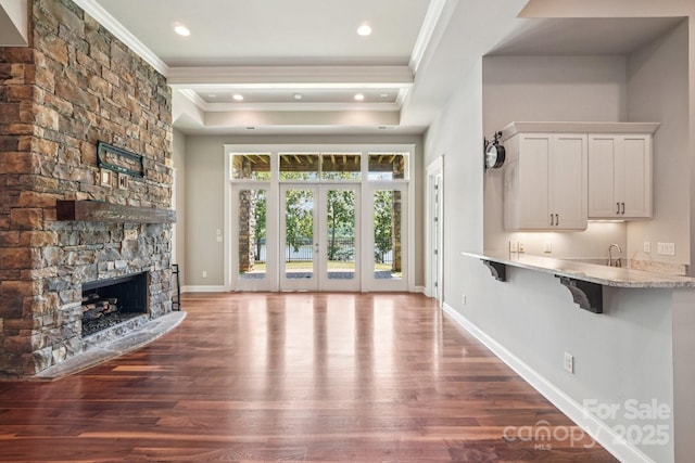 3229 Lake Pointe Dr, Belmont, NC 28012 - unfurnished living room featuring ornamental molding, dark wood-style flooring, a stone fireplace, a raised ceiling, and recessed lighting