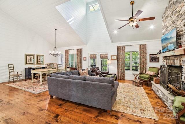 1092 E Bald Rock Dr, Sapphire, NC 28774 - living room featuring high vaulted ceiling, a stone fireplace, a ceiling fan, wood-type flooring, and a chandelier