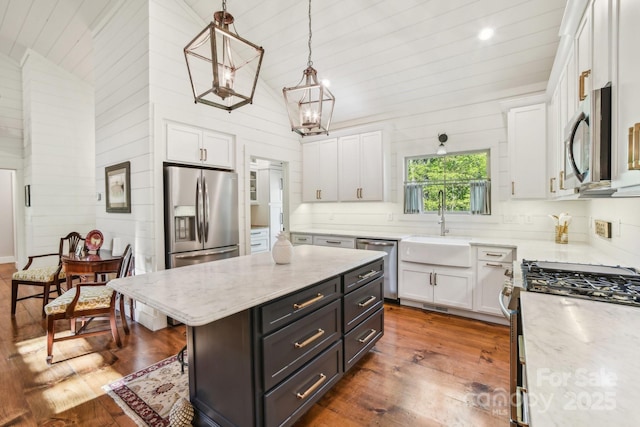 1092 E Bald Rock Dr, Sapphire, NC 28774 - kitchen featuring white cabinets, appliances with stainless steel finishes, wood finished floors, vaulted ceiling, and wood walls