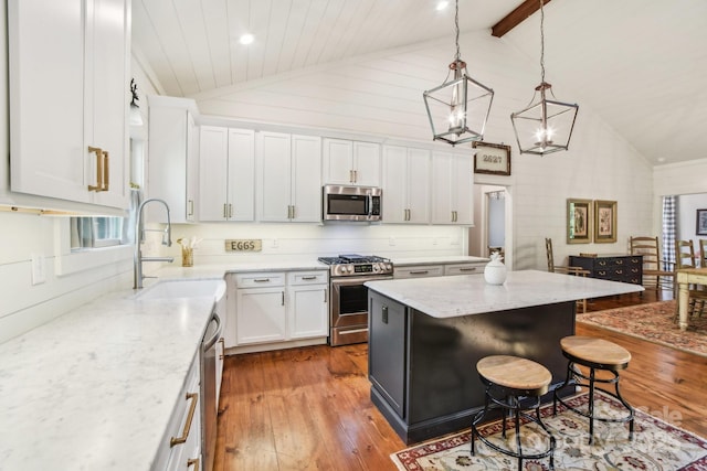 1092 E Bald Rock Dr, Sapphire, NC 28774 - kitchen featuring appliances with stainless steel finishes, hardwood / wood-style floors, white cabinetry, a kitchen breakfast bar, and a center island