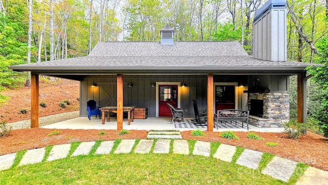 1092 E Bald Rock Dr, Sapphire, NC 28774 - rear view of property featuring a chimney, board and batten siding, a shingled roof, and stone siding