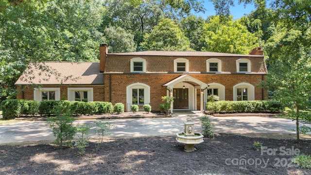 630 Burrage Rd NE, Concord, NC 28025 - view of front of property with a chimney, brick siding, and roof with shingles