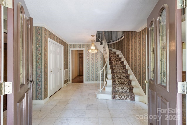630 Burrage Rd NE, Concord, NC 28025 - foyer with wallpapered walls, stairway, a textured ceiling, and ornamental molding