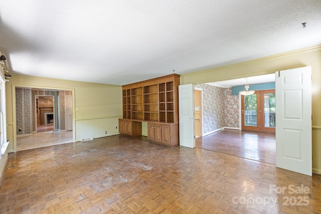 630 Burrage Rd NE, Concord, NC 28025 - unfurnished living room with wallpapered walls, a textured ceiling, and ornamental molding