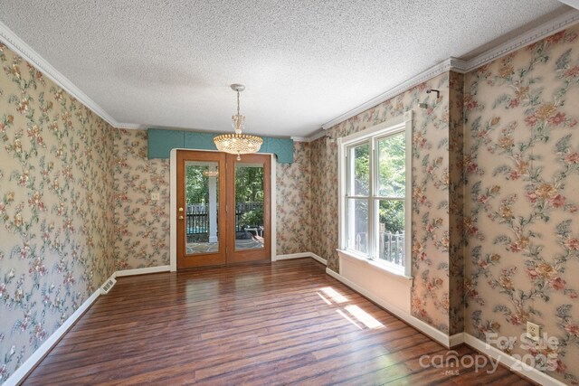 630 Burrage Rd NE, Concord, NC 28025 - unfurnished dining area featuring wood finished floors, a textured ceiling, ornamental molding, a chandelier, and wallpapered walls