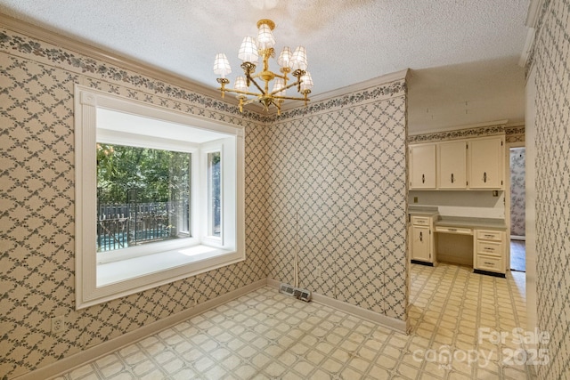 630 Burrage Rd NE, Concord, NC 28025 - unfurnished dining area with light flooring, a chandelier, crown molding, a textured ceiling, and wallpapered walls