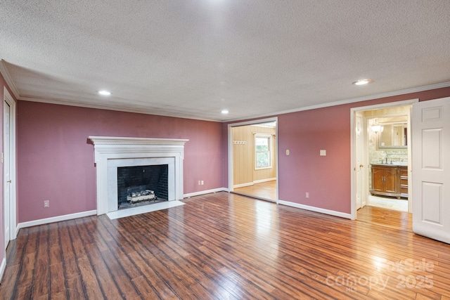 630 Burrage Rd NE, Concord, NC 28025 - unfurnished living room with ornamental molding, a textured ceiling, wood finished floors, a fireplace with flush hearth, and recessed lighting