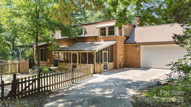 630 Burrage Rd NE, Concord, NC 28025 - view of front of house featuring a sunroom, concrete driveway, brick siding, roof with shingles, and an attached garage