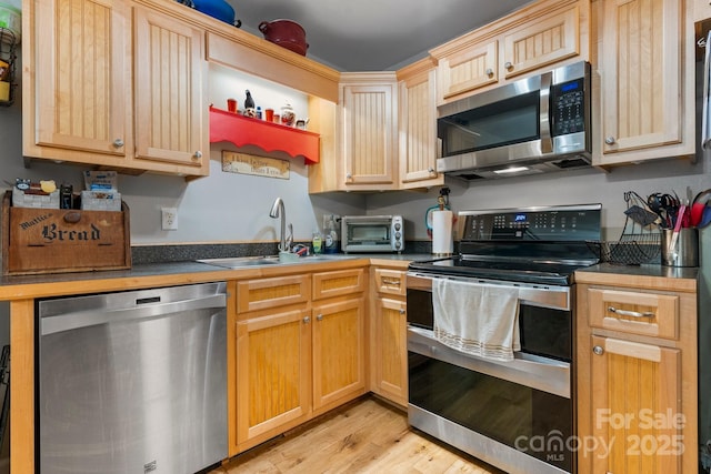 309 Sheldon St, Hudson, NC 28638 - kitchen with stainless steel appliances, light wood-style floors, and light brown cabinetry