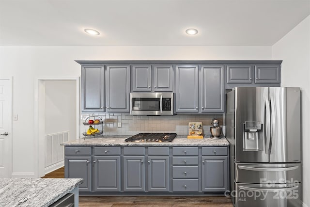 1528 Autumn Brook Ln, York, SC 29745 - kitchen with appliances with stainless steel finishes, gray cabinets, dark wood finished floors, backsplash, and light stone countertops