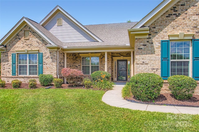5237 Afterglow Ave, Concord, NC 28025 - view of front of house featuring a front yard, a shingled roof, and brick siding