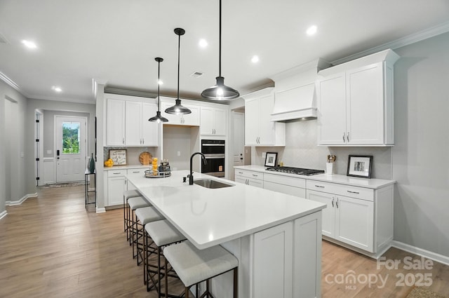 9945 Cask Way, Huntersville, NC 28078 - kitchen featuring crown molding, stainless steel gas stovetop, decorative backsplash, custom range hood, and light wood finished floors