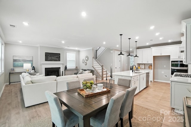 9945 Cask Way, Huntersville, NC 28078 - dining space featuring recessed lighting, stairs, ornamental molding, light wood-style flooring, and a fireplace