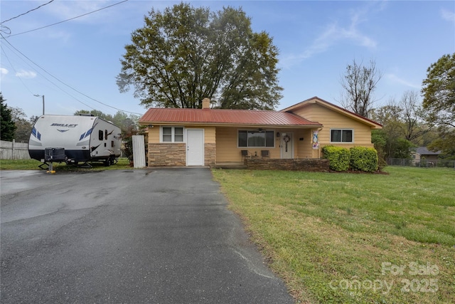 143 W College St, Stanley, NC 28164 - ranch-style house with a chimney, a front yard, stone siding, and a metal roof