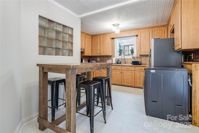 143 W College St, Stanley, NC 28164 - kitchen featuring refrigerator, tasteful backsplash, light brown cabinetry, and a breakfast bar
