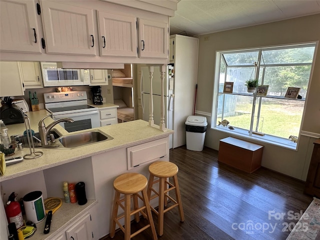 104 Pine St Unit 201, New London, NC 28127 - kitchen with white appliances, white cabinets, dark wood finished floors, a breakfast bar, and open shelves