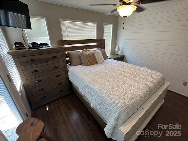 104 Pine St Unit 201, New London, NC 28127 - bedroom featuring dark wood-style floors, multiple windows, wooden walls, and a ceiling fan
