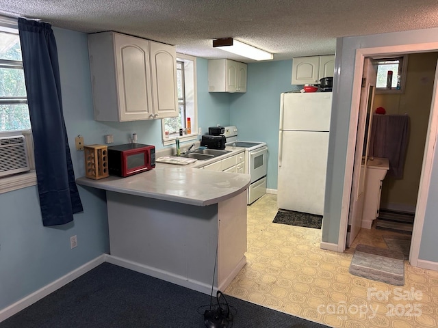 3036 Holly Hill Rd, Hendersonville, NC 28792 - kitchen featuring white appliances, a peninsula, light countertops, a textured ceiling, and white cabinetry