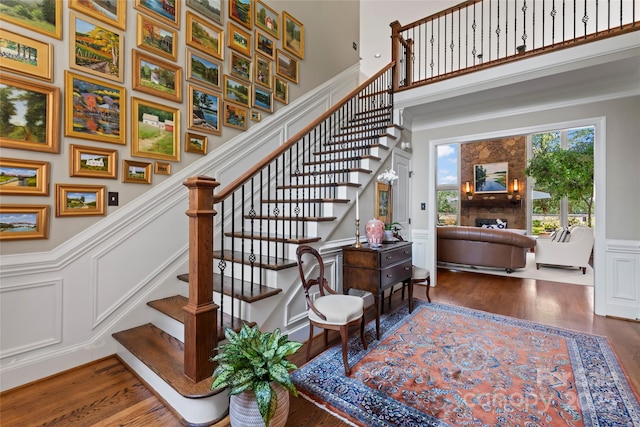 19245 Stableford Ln, Cornelius, NC 28031 - stairs with a decorative wall, wood finished floors, a wainscoted wall, a towering ceiling, and ornamental molding