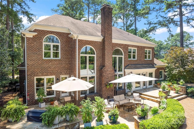 19245 Stableford Ln, Cornelius, NC 28031 - back of house featuring a patio, a chimney, brick siding, an outdoor hangout area, and a shingled roof