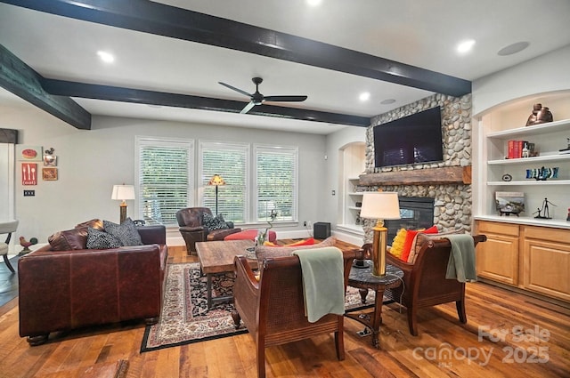 5005 Craftsman Ridge Dr, Matthews, NC 28104 - living area with wood-type flooring, a ceiling fan, beam ceiling, a stone fireplace, and arched walkways