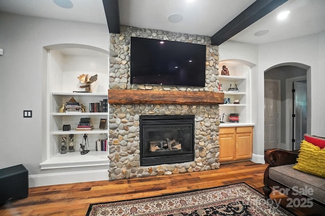 5005 Craftsman Ridge Dr, Matthews, NC 28104 - living area featuring beam ceiling, wood finished floors, a stone fireplace, and built in shelves