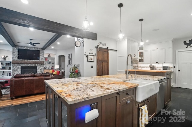 5005 Craftsman Ridge Dr, Matthews, NC 28104 - kitchen with ceiling fan, a barn door, beam ceiling, white cabinets, and recessed lighting