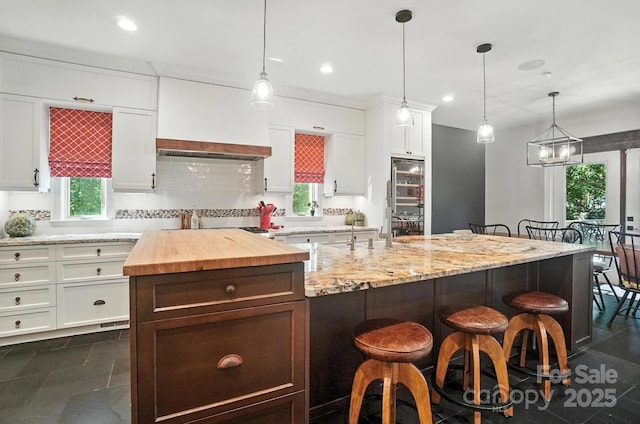 5005 Craftsman Ridge Dr, Matthews, NC 28104 - kitchen with wooden counters, healthy amount of natural light, a kitchen bar, white cabinetry, and recessed lighting