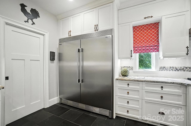 5005 Craftsman Ridge Dr, Matthews, NC 28104 - kitchen featuring built in fridge, white cabinets, tasteful backsplash, and dark tile patterned flooring