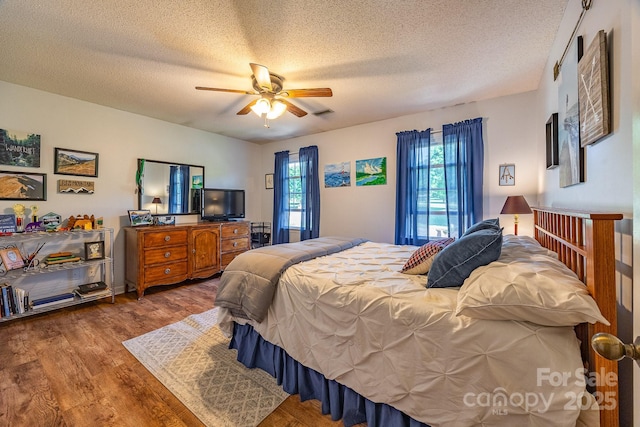302 Redwood Pl, Lenoir, NC 28645 - bedroom featuring multiple windows, wood finished floors, a textured ceiling, and a ceiling fan