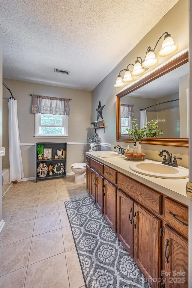 302 Redwood Pl, Lenoir, NC 28645 - full bath featuring double vanity, a textured ceiling, tile patterned flooring, and shower / tub combo